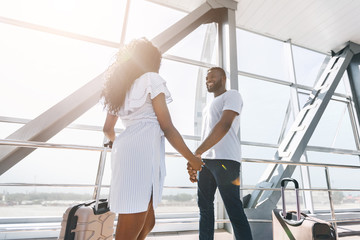 Black couple greeting each other after long separation at airport