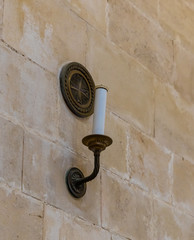 Candlestick with a candle hanging on the wall in the catholic Christian Transfiguration Church located on Mount Tavor near Nazareth in Israel