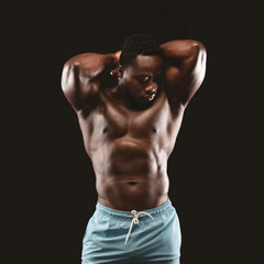 Fototapeta na wymiar Portrait of hot black bodybuilder showing his muscles