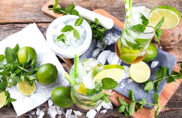 Mohito lime drinks on wooden with blur beach background. Fresh drinks with fruits on wood. Summer concept