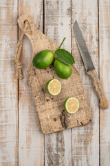 sliced limes on a wooden cutting board on a table