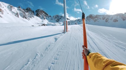 Snowboard or ski rider on drag lift pov
