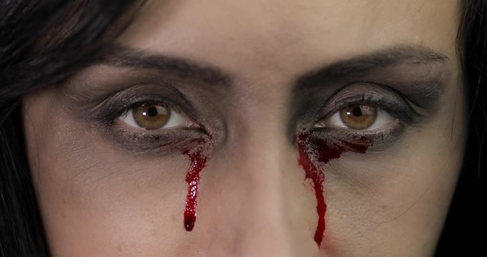 Vampire Halloween woman portrait. Vampire girl with dripping blood near eyes
