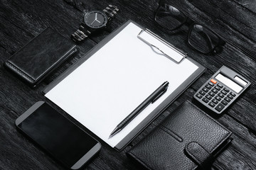 Business plan template. Questionnaire form template. Agreement or contract. Blank white paper page with a copy space on a clipboard and other businessman accessories on black background.