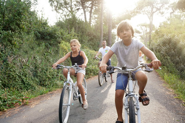 Fototapeta na wymiar Happy family on vacation riding bikes