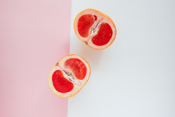 Half grapefruit citrus fruit on paper background. Closeup view, flat lay