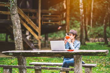Naklejka premium Cute girl working and driniking coffee on table in vacation holiday time on hills beautiful nature