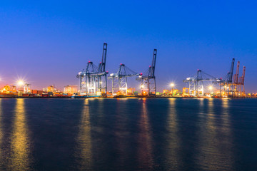 Cargo freight ship and cargo container working with crane at port area,Logistic Import Export at night, Thailand 4.0