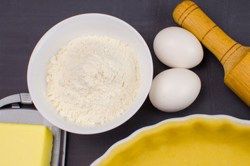shortbread dough for baking quiche tart and ingredients in baking form with berries. baking concept