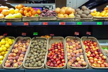 Fototapeta na wymiar Supermarket fruit zone. A variety of fruits on shelves of store.
