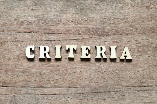 Letter block in word criteria on wood background