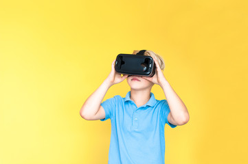 Little boy holds virtual reality hand 3D glasses on his head