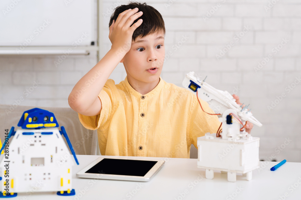 Poster Shocked schoolboy made mistake when creating robot at stem class