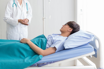 Obraz premium Beautiful female doctor in white medical coat is consulting her patient, showing the result of health check.