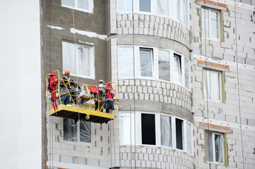 Workers are building a modern high-rise house