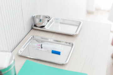 close up syringe and treatment stuff on the table in the hospital, health care and medical concept.