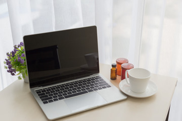 Fototapeta premium Close up laptop with coffee and bottles of pills.