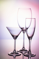 Empty glass goblets set. On a colored purple background abstract