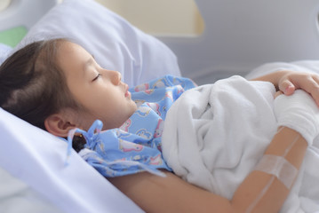 Obraz na płótnie Canvas Patient child sleeping on hospital bed with saline solution intravenous