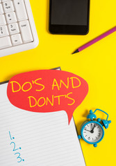 Text sign showing Do S Is And Dont S Is. Business photo showcasing advising Rules or customs concerning some activity Empty red bubble paper on the table with pc keyboard