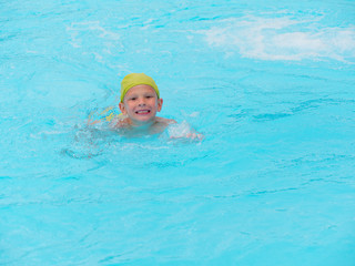 boy swims in a pool with blue water