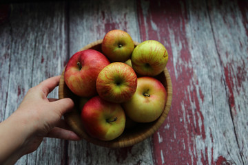 Autumn apples bowl wooden background hand