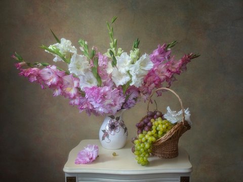 Still life with bouquet of gladiolus flowers in a vase on wooden table