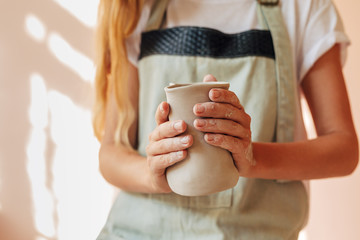 Hands of unrecognizable woman holding an unfinished mug