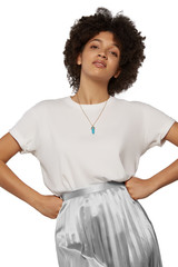 The medium front shot of a young lady with a golden chainlet with a pendant in the form of screw with a fitted-in aquamarine gemstone similar to a turquoise without spots.  © RedUmbrella&Donkey