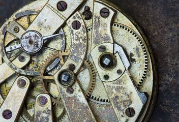 Fototapeta na wymiar Gears of a vintage metal business clock watch close-up background, time mechanism, timing concept
