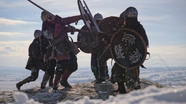 Warriors of vikings are fighting during attack at winter time.