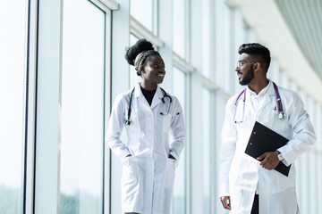 Two doctors discussing diagnosis while walking in hospital