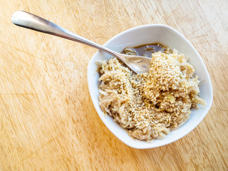 fork in grated kohlrabi salad with sesame seeds