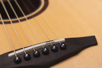 Acoustic guitar, focus on the saddle.