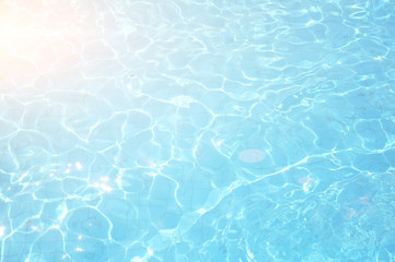 Swimming pool bottom caustics ripple and flow with waves background. Summer background. Texture of water surface.