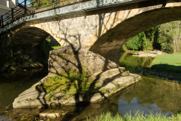 Pont et arches de pont en pierre au dessus d'une rivière pour passer d'une rive à l'autre