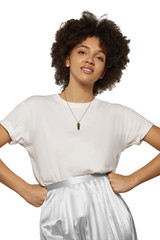 The medium front shot of a young mulatta lady with a golden chainlet with a pendant in the form of screw with a fitted-in green gemstone similar to an axe-stone on her neck.  © RedUmbrella&Donkey