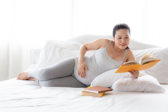 Pregnancy and motherhood concept - Happy pregnant woman reading book on relaxing time.