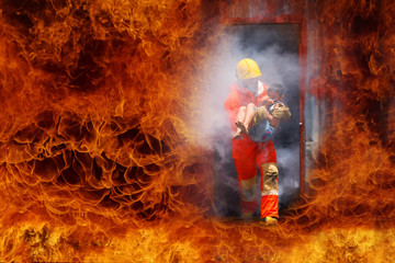 Brave Firefighter hold saved a boy in his arms in case of fire. Firefighter concept.
