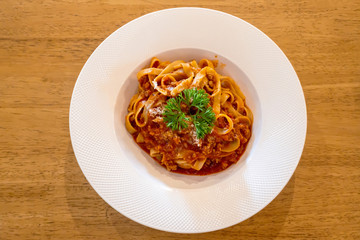 Spaghetti with white disc on wooden table