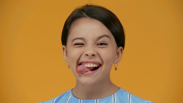 funny preteen child grimacing isolated on yellow
