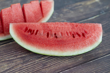 Close up of ripe watermelon red color look fresh on old wood plate. Close up and selective Focus.