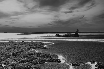 sunset behind an old shipwreck. Zeeland, The Netherlands.