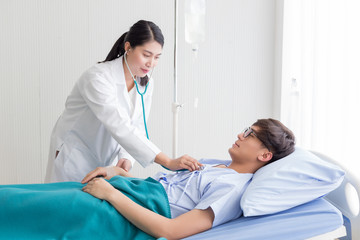 Close up young Asian doctor injecting medicine for the patient on the bed