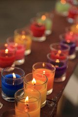 Colorful candle, praying with faith, traditional visit of a holy place, belief in God or miracle concept.