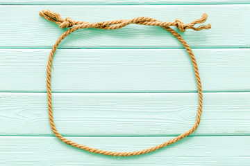 rope frame on mint green wooden background top view mock-up