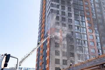 Fototapeta premium fireman climbing a ladder with water hose for extinguish fire