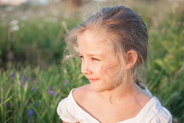 Closeup portrait of a beautiful little girl outdoors in summer day