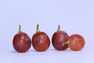 fresh purple grapes put down on white