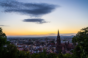 Germany, Beautiful city freiburg im breisgau in warm orange sunset atmosphere seen from above in summer